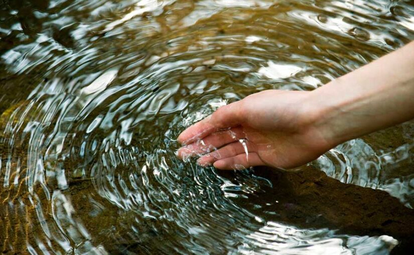 Mano en agua de río